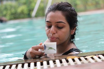 Close-up of woman drinking tea in swimming pool