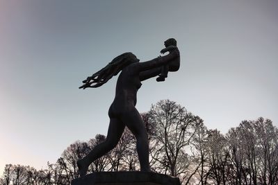 Low angle view of silhouette statue against sky