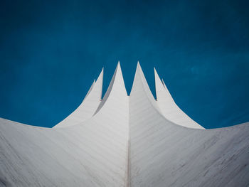 Low angle view of modern built structure against blue sky