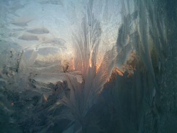 Sunset seen through frozen glass window
