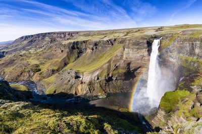 Scenic view of waterfall against sky