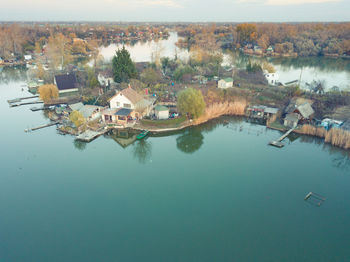 High angle view of buildings by trees against sky