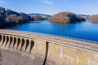 Scenic view of swimming pool by lake against sky