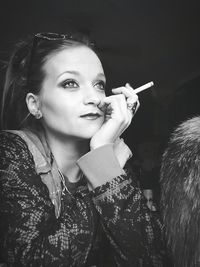 Young woman looking away while smoking