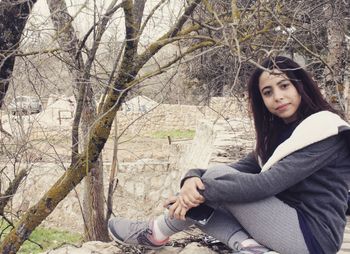 Portrait of a young woman sitting outdoors