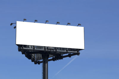 Low angle view of crane against clear blue sky
