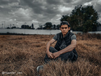 Portrait of young man on field against sky