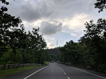 Road amidst trees against sky