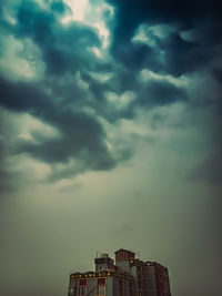 Low angle view of building against cloudy sky