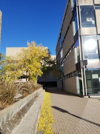 Footpath amidst buildings against sky