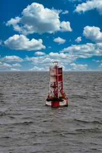 Red boat in sea against sky