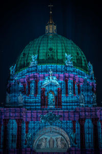 Illuminated building against sky at night