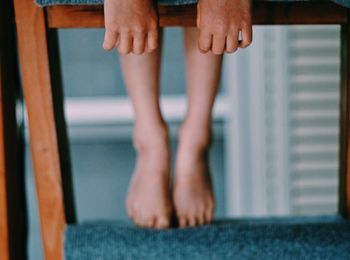Low section of woman standing on ladder