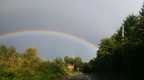 Scenic view of rainbow over road against sky