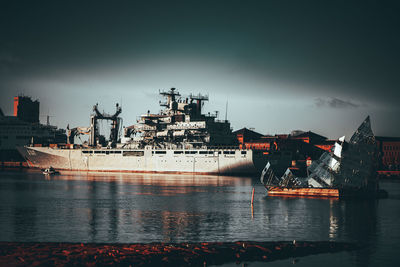 Cranes at harbor against sky
