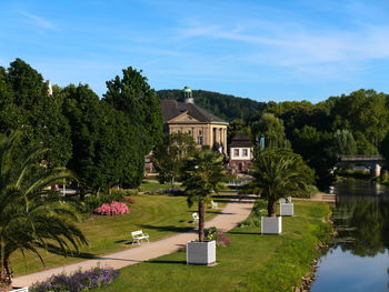 Scenic view of garden by buildings against sky. regentenbau