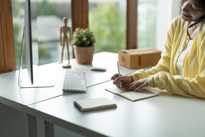 Midsection of woman working on table