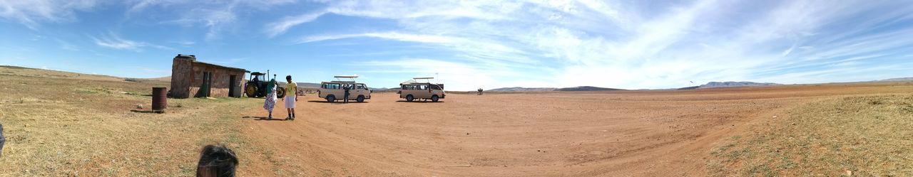 Panoramic view of dirt road on desert against sky