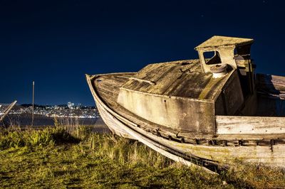 Shipwreck on field against clear sky