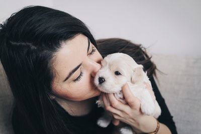 Close-up of woman holding dog at home