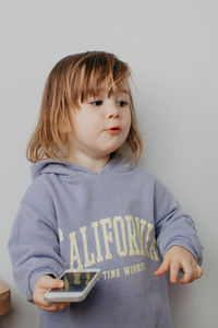 Portrait of girl standing against wall