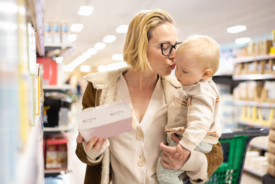 Young woman using mobile phone in supermarket