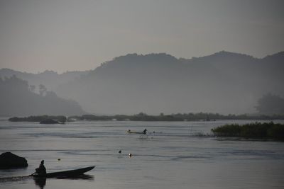 Scenic view of lake by mountains against sky