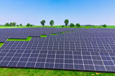 Solar panels in green field, aerial view