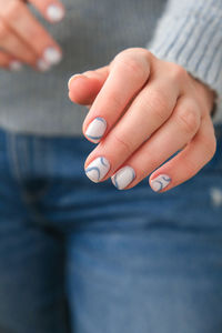 Manicured female hands with stylish blue nails and minimalistic design. trendy modern design manicur