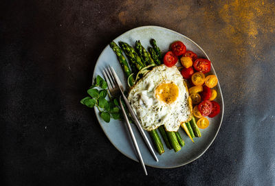 Organic grilled asparagus served for healthy keto lunch on stone background with copy space