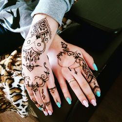 Cropped hand of woman with heena tattoo