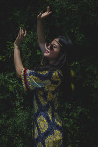 Young woman standing by plants