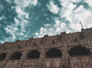 Low angle view of historical building against cloudy sky