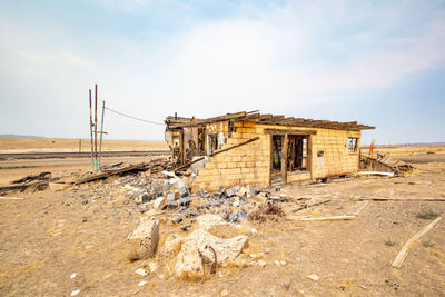 Abandoned built structure on sand against sky