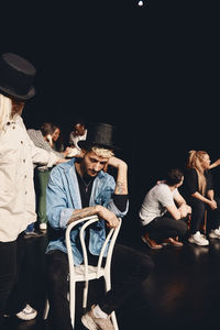 Sad man wearing hat practicing act with woman on stage