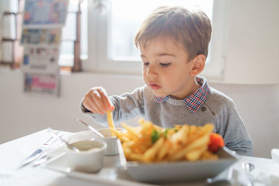 Close-up of boy having fries