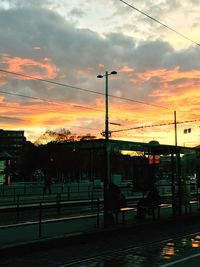 City street against cloudy sky at sunset
