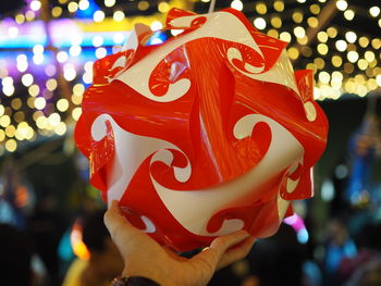 Close-up of woman holding illuminated christmas decorations at night