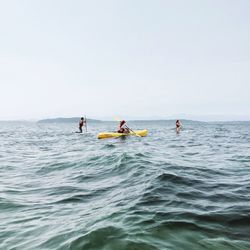 People in sea against sky