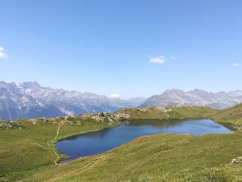 Scenic view of lake and mountains against blue sky