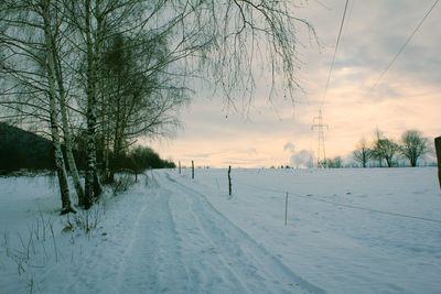 Scenic view of snow covered field against sky