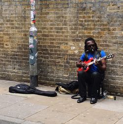 Full length of man sitting in city