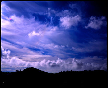 Low angle view of silhouette landscape against dramatic sky