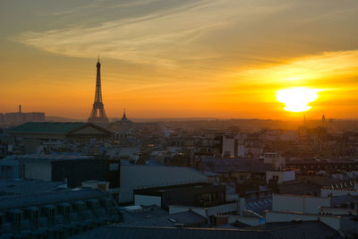 Aerial view of buildings in city during sunset