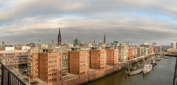 High angle view of buildings by canal against sky