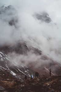 Group of people on mountain during foggy weather