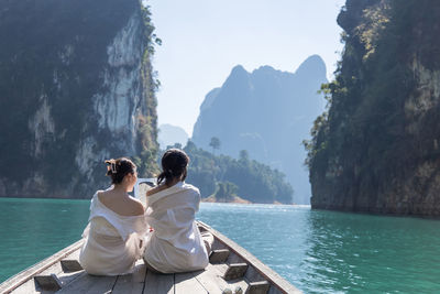 Rear view of couple sitting on mountain