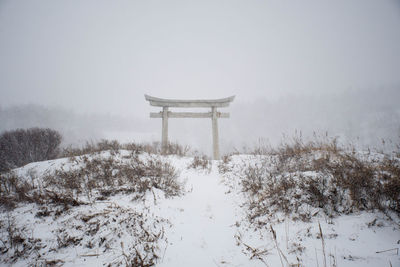 Lifeguard hut on snow covered field against sky