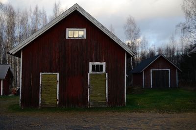 House amidst trees and buildings against sky