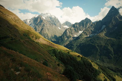 Scenic view of green mountains against sky